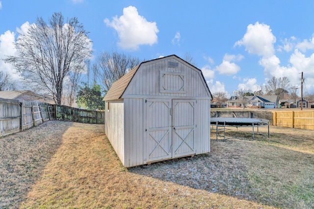 view of outbuilding with a trampoline and a yard