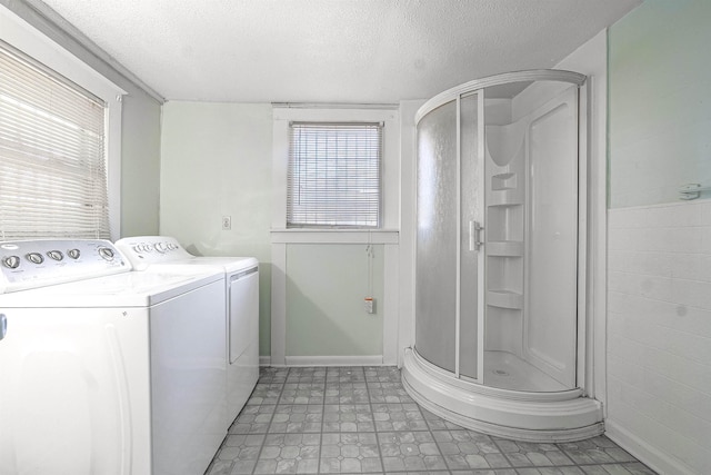 laundry area with a textured ceiling, plenty of natural light, and washing machine and clothes dryer