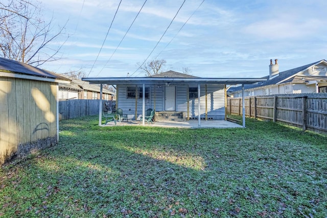 back of house with a patio area and a lawn