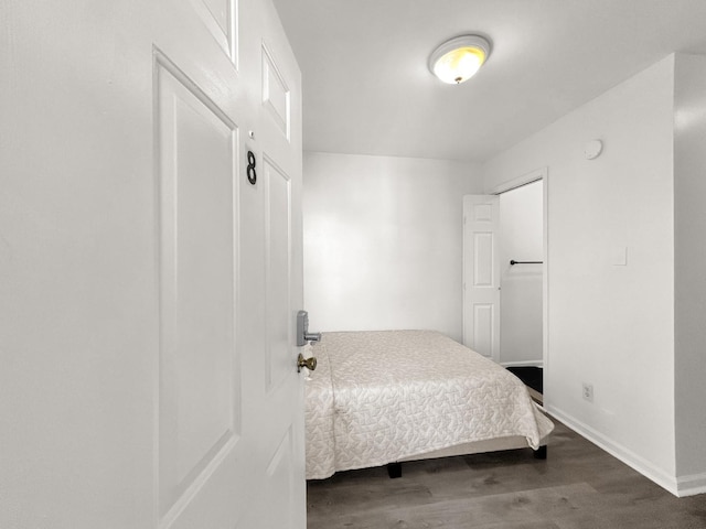 bedroom with dark wood-type flooring