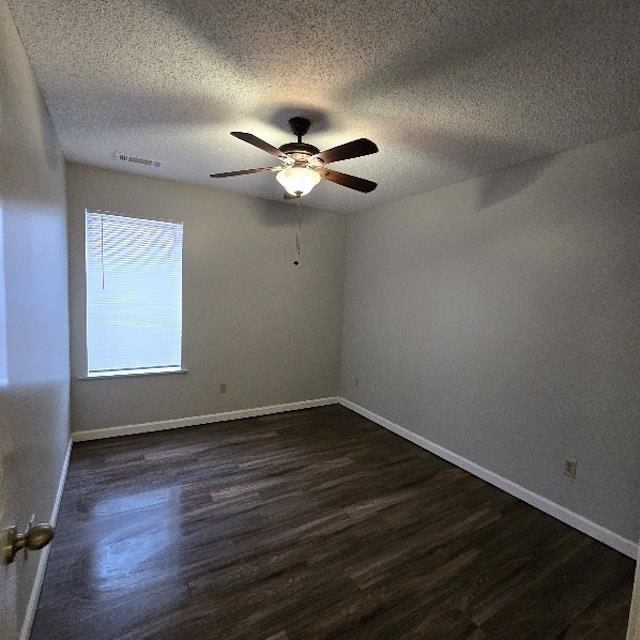 unfurnished room featuring a textured ceiling, ceiling fan, and dark hardwood / wood-style flooring