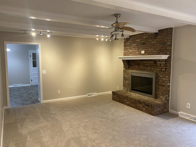 unfurnished living room featuring a brick fireplace, ceiling fan, beamed ceiling, and carpet flooring