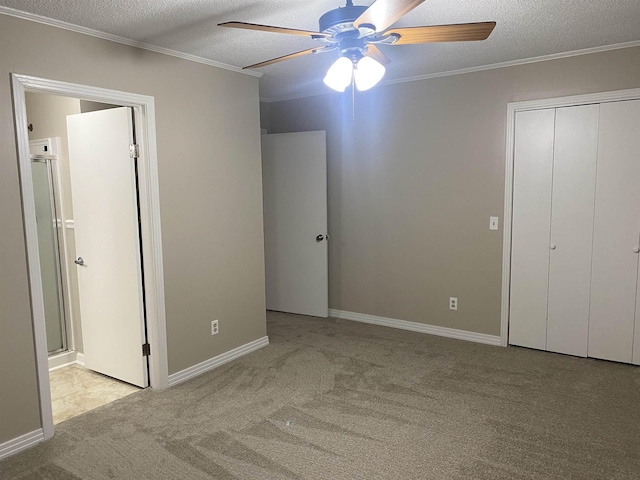 unfurnished bedroom featuring light carpet, ceiling fan, a textured ceiling, and crown molding