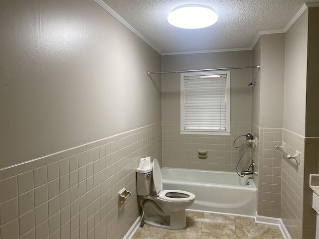 bathroom with a textured ceiling, toilet, ornamental molding, and tile walls