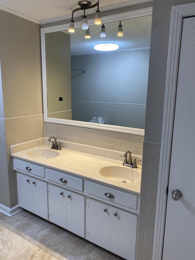 bathroom with vanity, tile walls, tile patterned floors, ornamental molding, and a textured ceiling