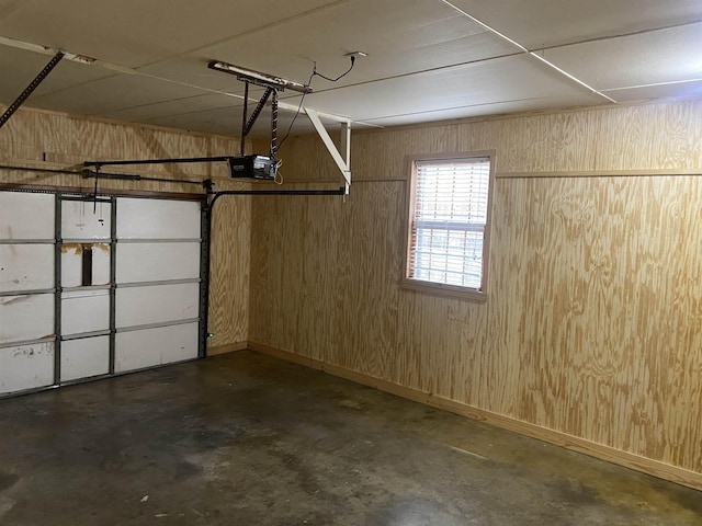 garage with a garage door opener and wooden walls