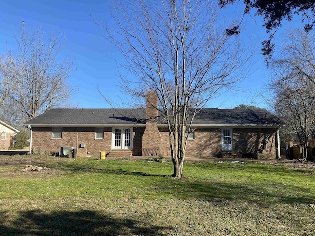 back of property with cooling unit and a lawn