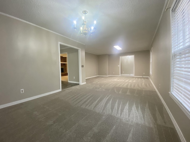 unfurnished room featuring dark carpet, crown molding, a textured ceiling, and an inviting chandelier