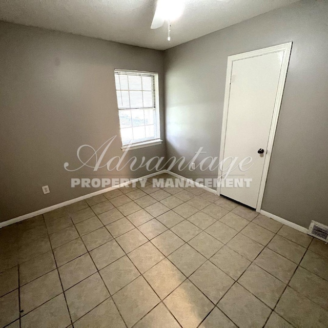 empty room featuring ceiling fan and light tile patterned flooring