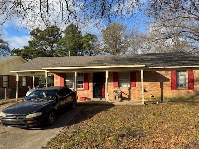 single story home featuring a front lawn and a carport