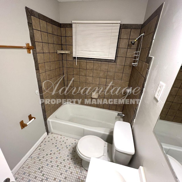 bathroom with tiled shower / bath, tile patterned floors, and toilet