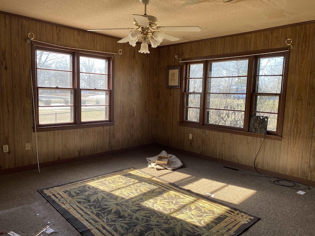 unfurnished room with ceiling fan, a textured ceiling, and carpet