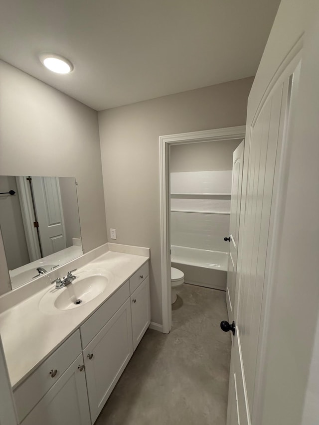 bathroom featuring vanity, concrete floors, and toilet