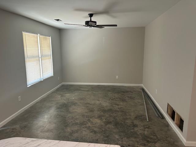 unfurnished room with ceiling fan and a healthy amount of sunlight