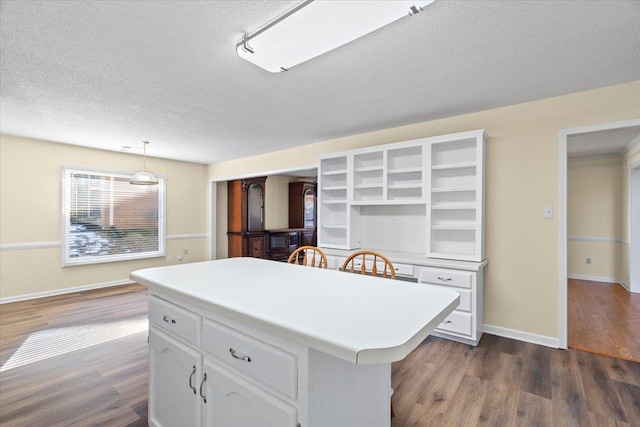 kitchen with white cabinetry, pendant lighting, dark hardwood / wood-style floors, and a center island