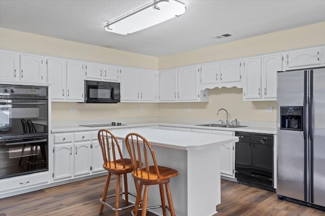 kitchen featuring black appliances, white cabinets, sink, and a kitchen island