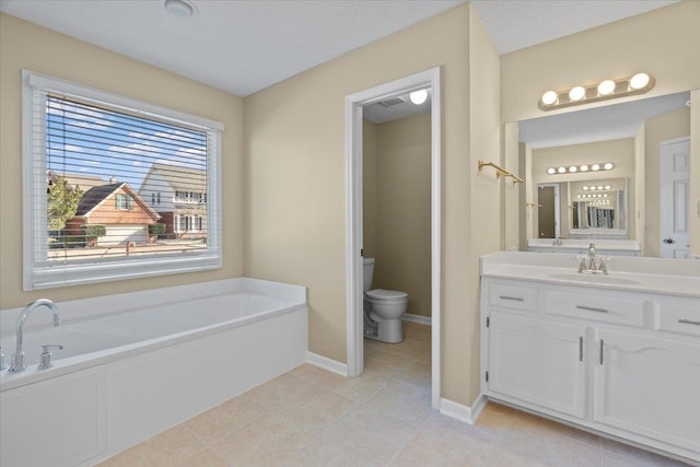 bathroom with a textured ceiling, tile patterned floors, vanity, a bathtub, and toilet