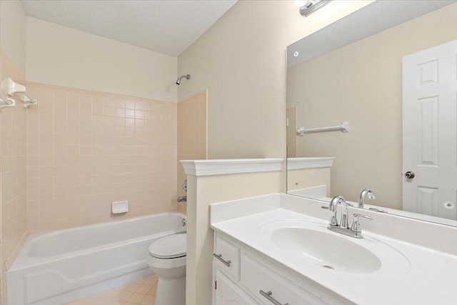 full bathroom featuring toilet, tiled shower / bath, tile patterned flooring, a textured ceiling, and vanity