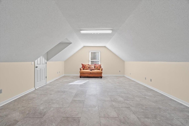 bonus room with a textured ceiling and lofted ceiling