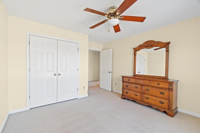 unfurnished bedroom with ceiling fan, a closet, and light carpet