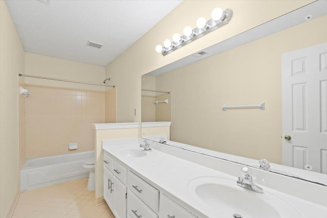 full bathroom with a textured ceiling, tiled shower / bath combo, tile patterned flooring, vanity, and toilet