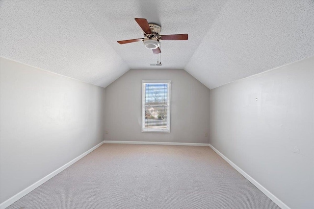 bonus room with light carpet, a textured ceiling, lofted ceiling, and ceiling fan