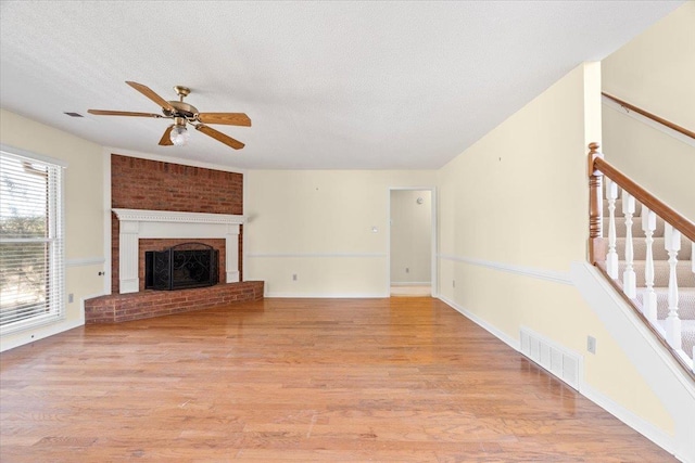 unfurnished living room featuring a textured ceiling, a fireplace, and light hardwood / wood-style flooring