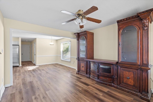 unfurnished living room featuring ceiling fan and hardwood / wood-style floors