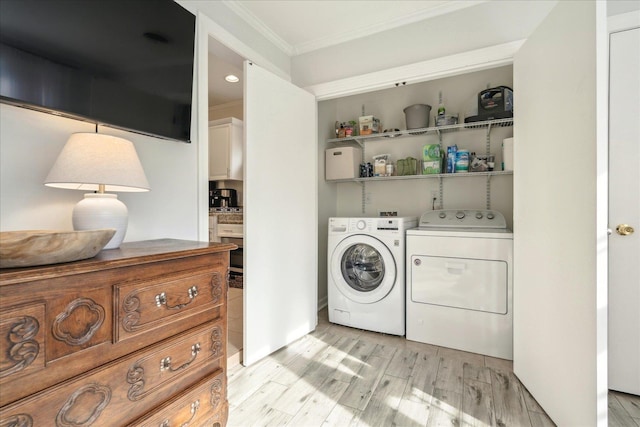 laundry area with crown molding, independent washer and dryer, and light hardwood / wood-style flooring