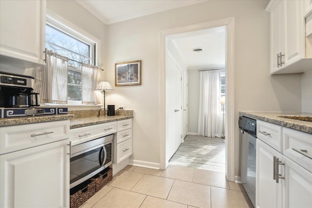 kitchen with white cabinets, appliances with stainless steel finishes, ornamental molding, light tile patterned flooring, and stone counters