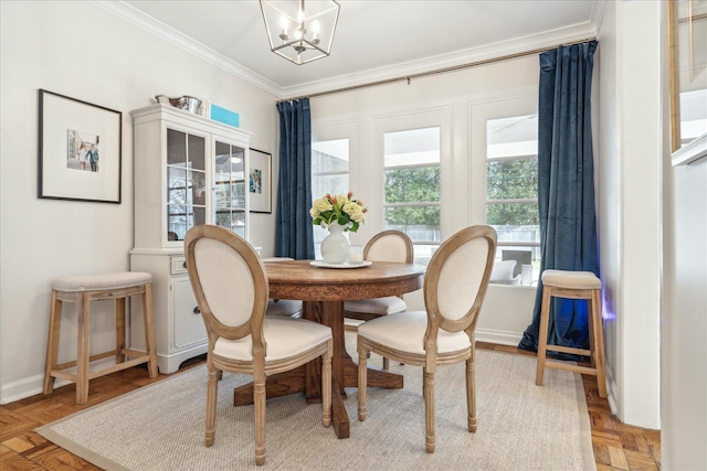 dining area with light parquet flooring, ornamental molding, and an inviting chandelier