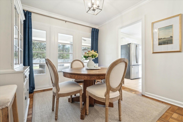 dining space featuring light parquet flooring, a notable chandelier, and ornamental molding