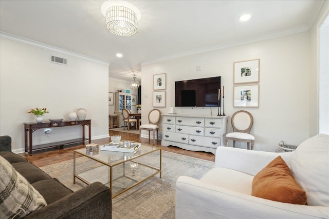 living room featuring light parquet floors, crown molding, and a notable chandelier