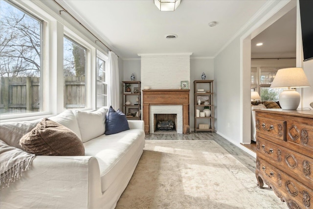 living room with a large fireplace, crown molding, and hardwood / wood-style flooring