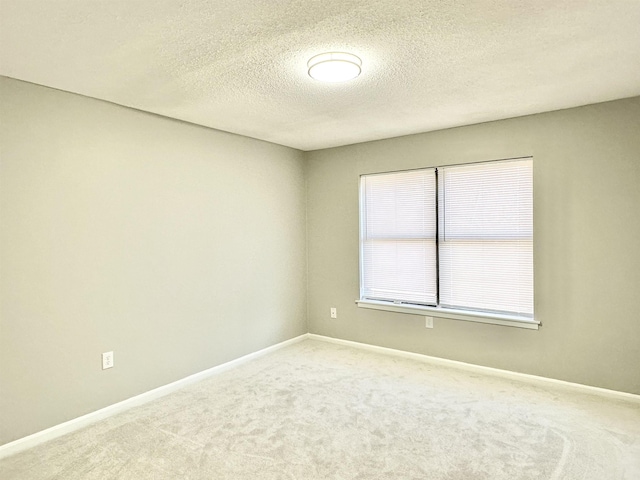 unfurnished room with carpet floors and a textured ceiling