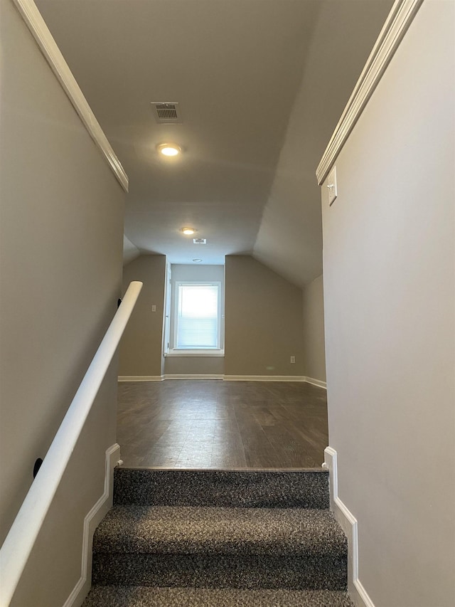 stairs with vaulted ceiling and crown molding