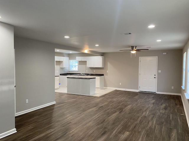 kitchen featuring ceiling fan, white cabinets, dark hardwood / wood-style flooring, and a kitchen island