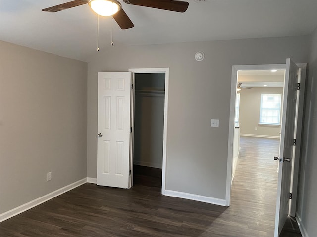 unfurnished bedroom with ceiling fan, a closet, and dark hardwood / wood-style flooring