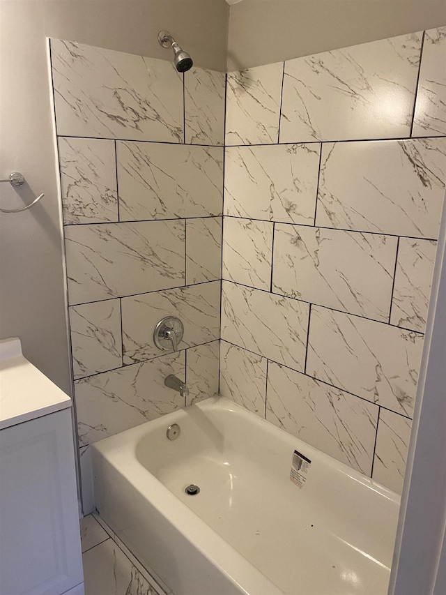 bathroom with tiled shower / bath combo and vanity