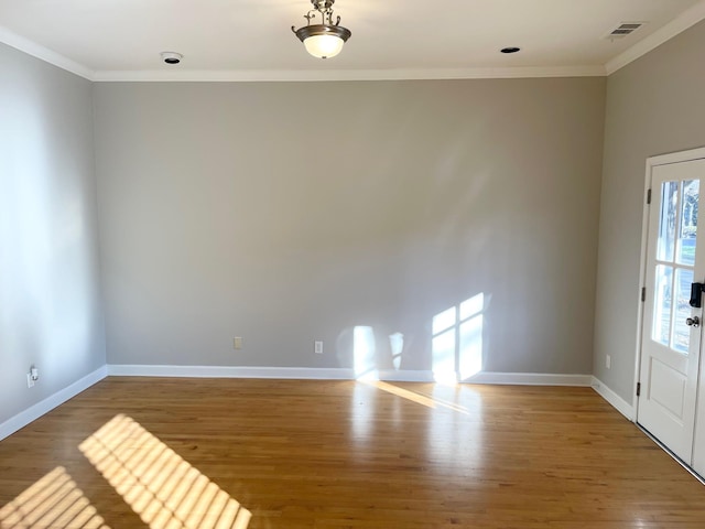 spare room with wood-type flooring and crown molding