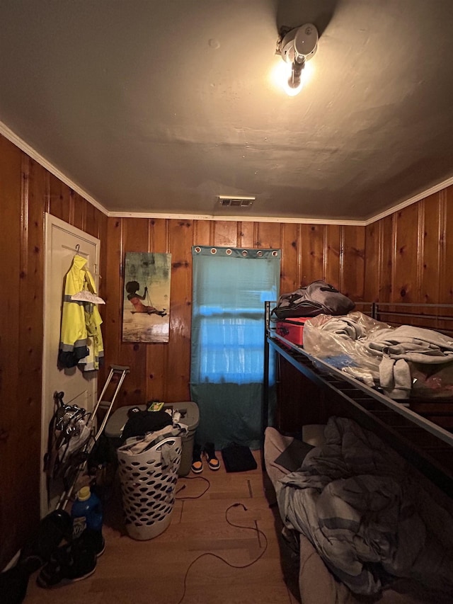 bedroom featuring wooden walls and ornamental molding