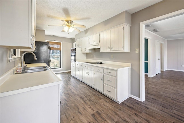 kitchen with a textured ceiling, white cabinets, black appliances, dark hardwood / wood-style flooring, and sink