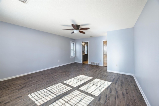 empty room with ceiling fan and dark hardwood / wood-style flooring