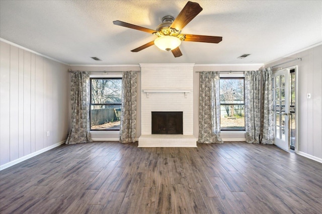 unfurnished living room with dark hardwood / wood-style floors, crown molding, and plenty of natural light