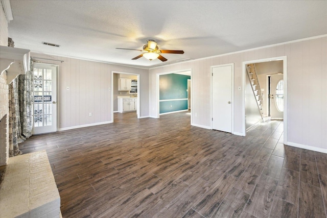 unfurnished living room featuring a textured ceiling, ceiling fan, dark hardwood / wood-style flooring, and ornamental molding