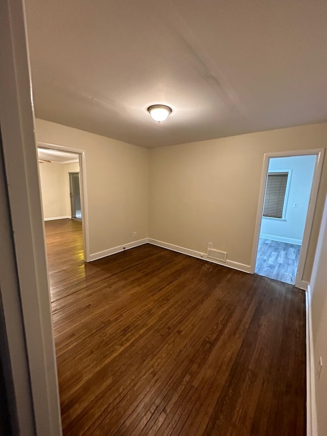 empty room featuring dark hardwood / wood-style flooring