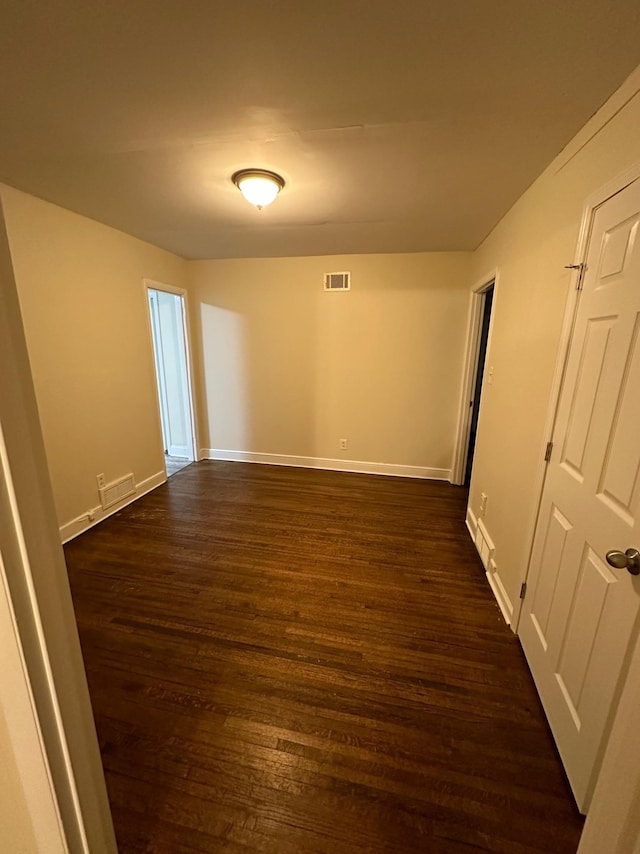 unfurnished room with dark hardwood / wood-style flooring