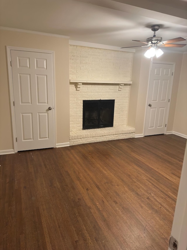 unfurnished living room with ceiling fan, crown molding, dark hardwood / wood-style floors, and a fireplace