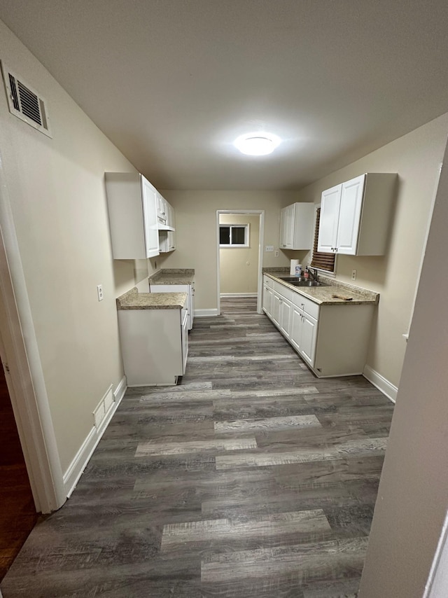 kitchen featuring sink, white cabinetry, dark hardwood / wood-style floors, and stove