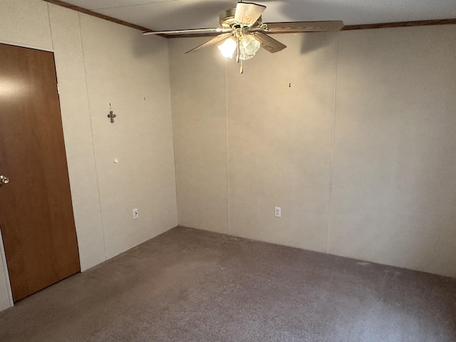 carpeted empty room with ceiling fan and ornamental molding